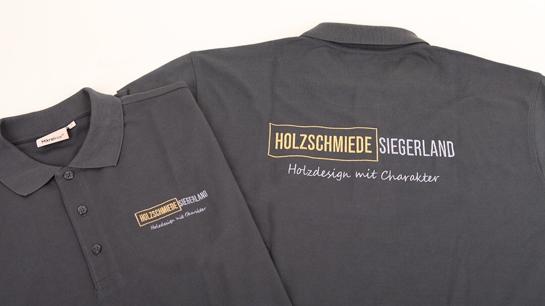 Abbildung von einer Bestickung für „Holzschmiede Siegerland“ auf einem Poloshirt